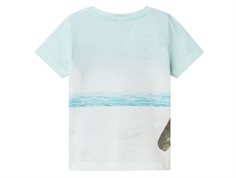 Name It T-Shirt bag fra med print af tyrannosarus Rex på en strand med surf boards, badering og palmer på forsiden 13243296 honeydew